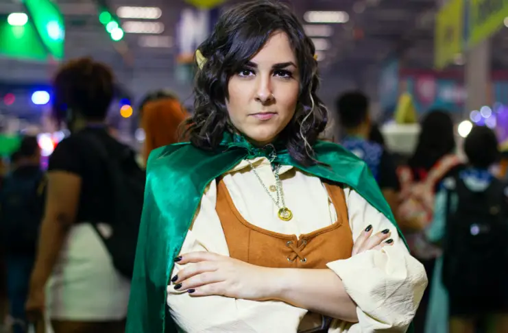 Woman in a Cosplay Standing with Arms Crossed among Crowd at a Fan Event