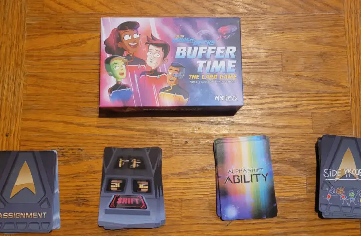 photo of the box for 'Star Trek: Lower Decks: Buffer Time" along with four stacks of cards (Assignment, Shift, Alpha Shift Ability, Side Project"