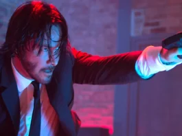 Keanu Reeves as John Wick points a gun towards the right