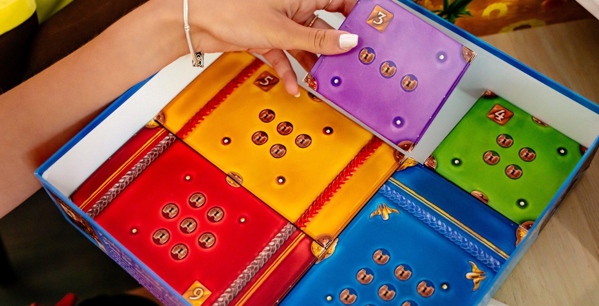 Image of the contents of the game box, five numbered boxes with lock symbols on them are shown.